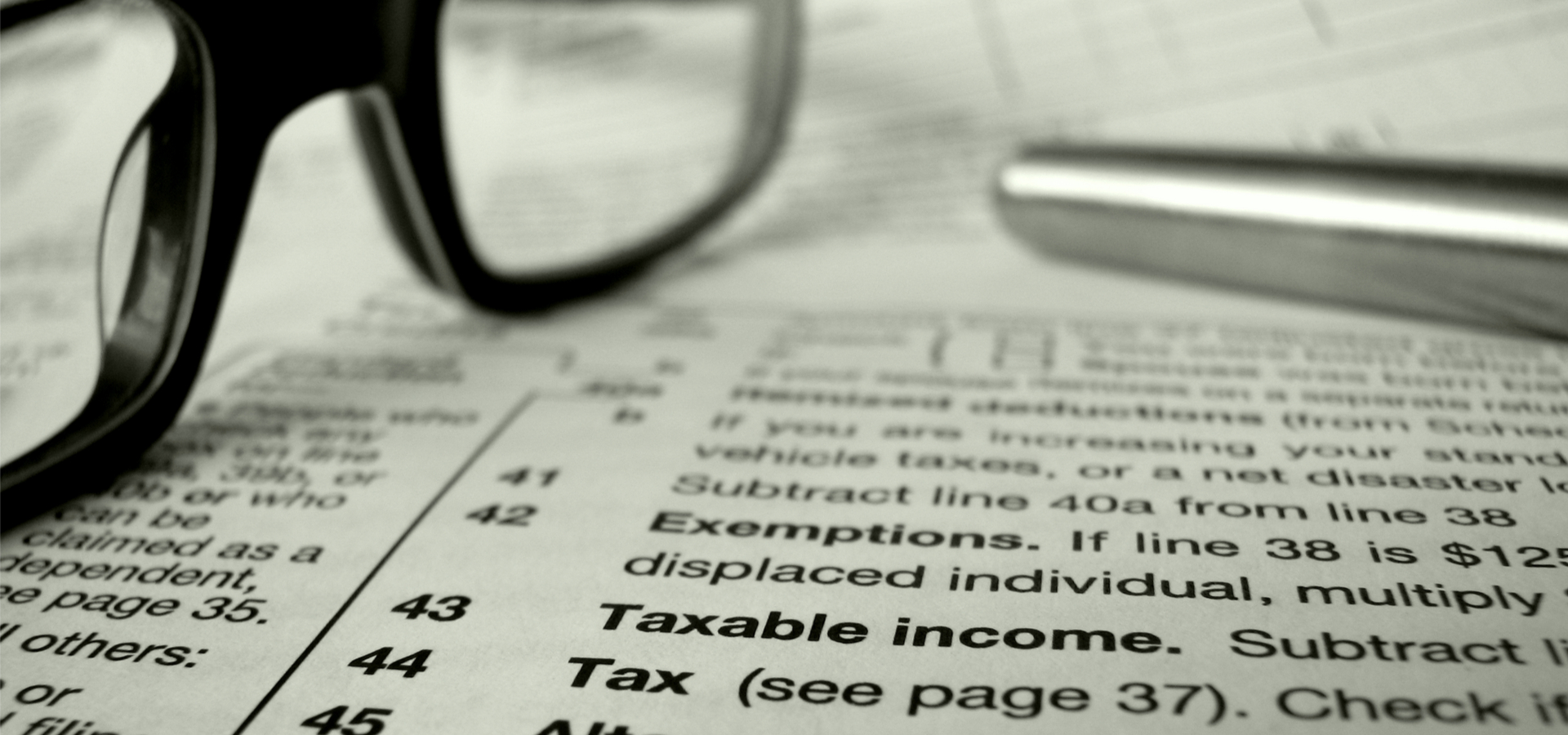 Financial Image Of Some Tax Forms With Glasses And A Pen